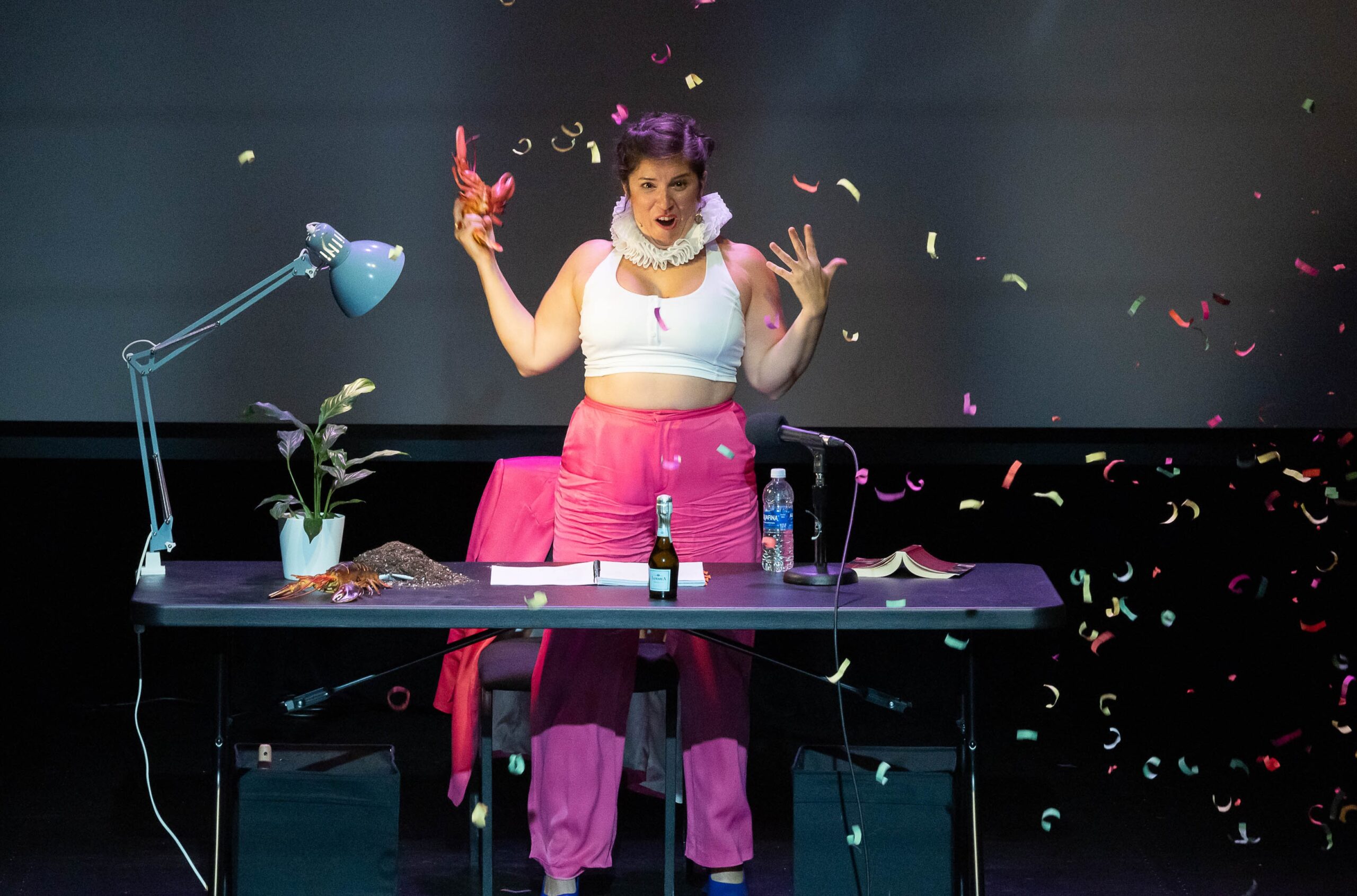 woman wearing neck cuff onstage surrounded by confetti