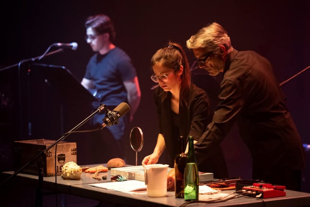Two performers on stage with audio equipment