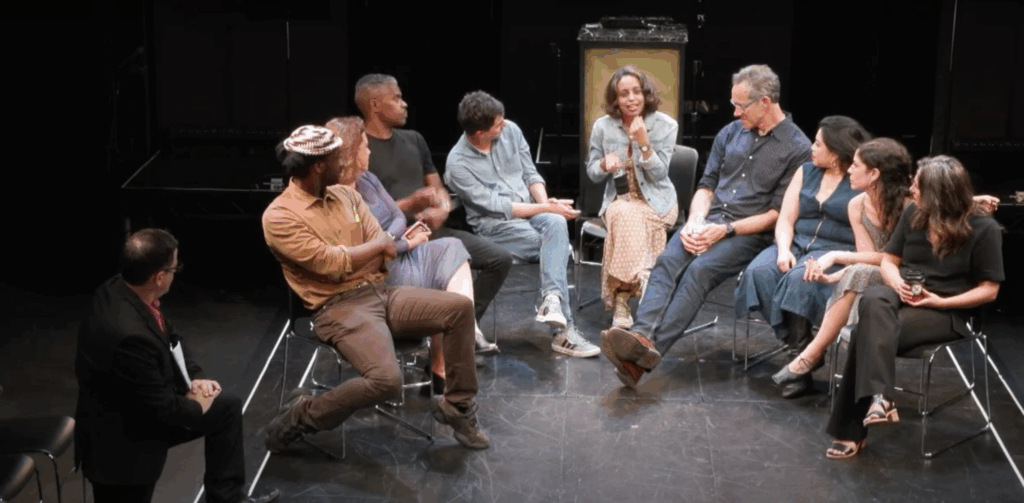 group of people sitting in a circle onstage